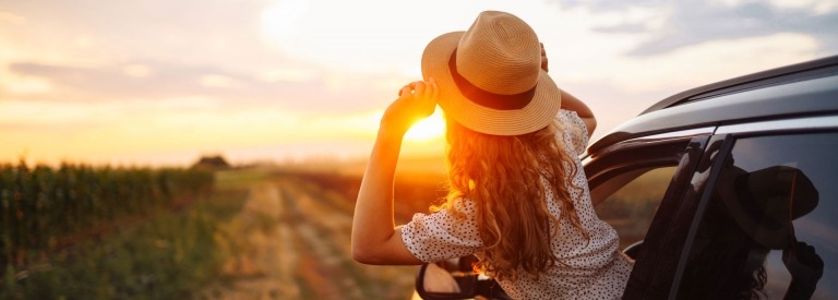 Ontspannen gelukkige vrouw op zomervakantie leunend uit autoraam